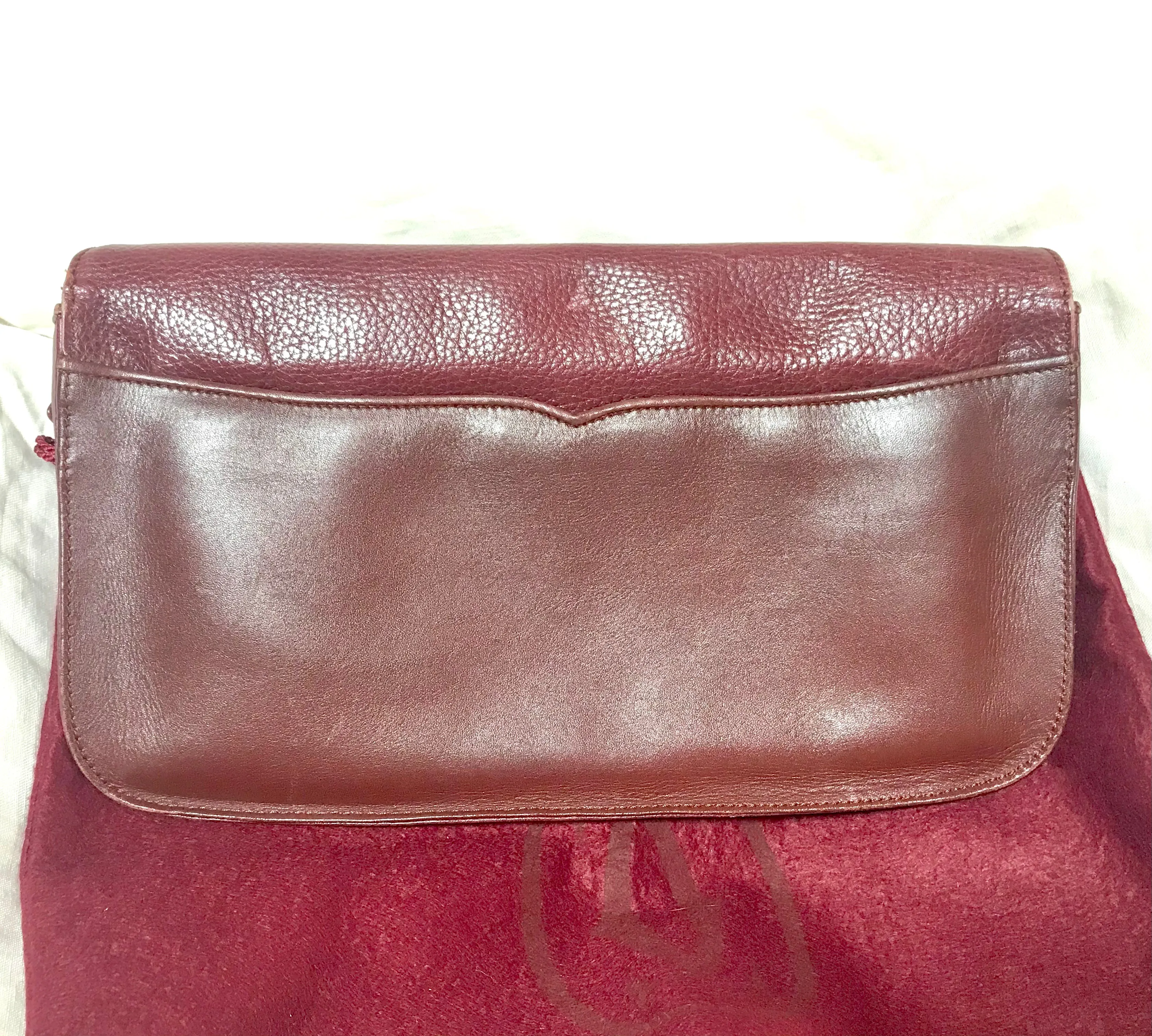Vintage Cartier wine leather clutch bag with gold tone logo motif. Classic purse from must de Cartier Collection.